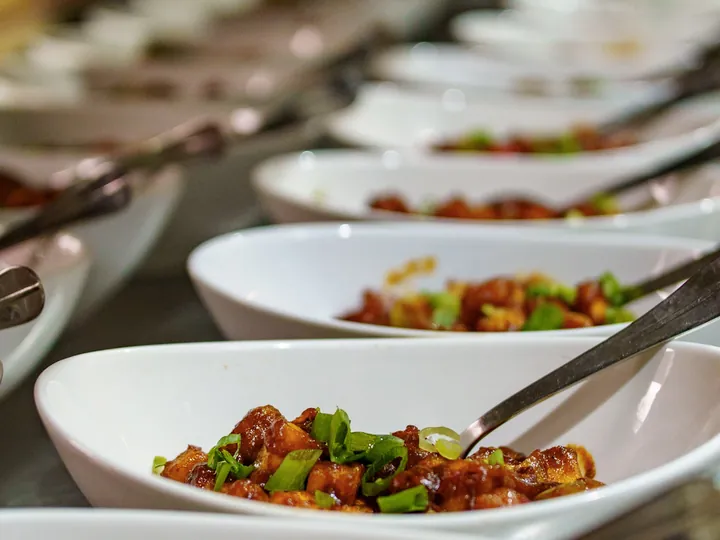 Bowls of chilli chicken garnished with spring onion