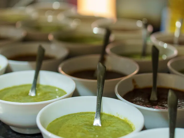 Rows of bowls with mint and tamarind chutney
